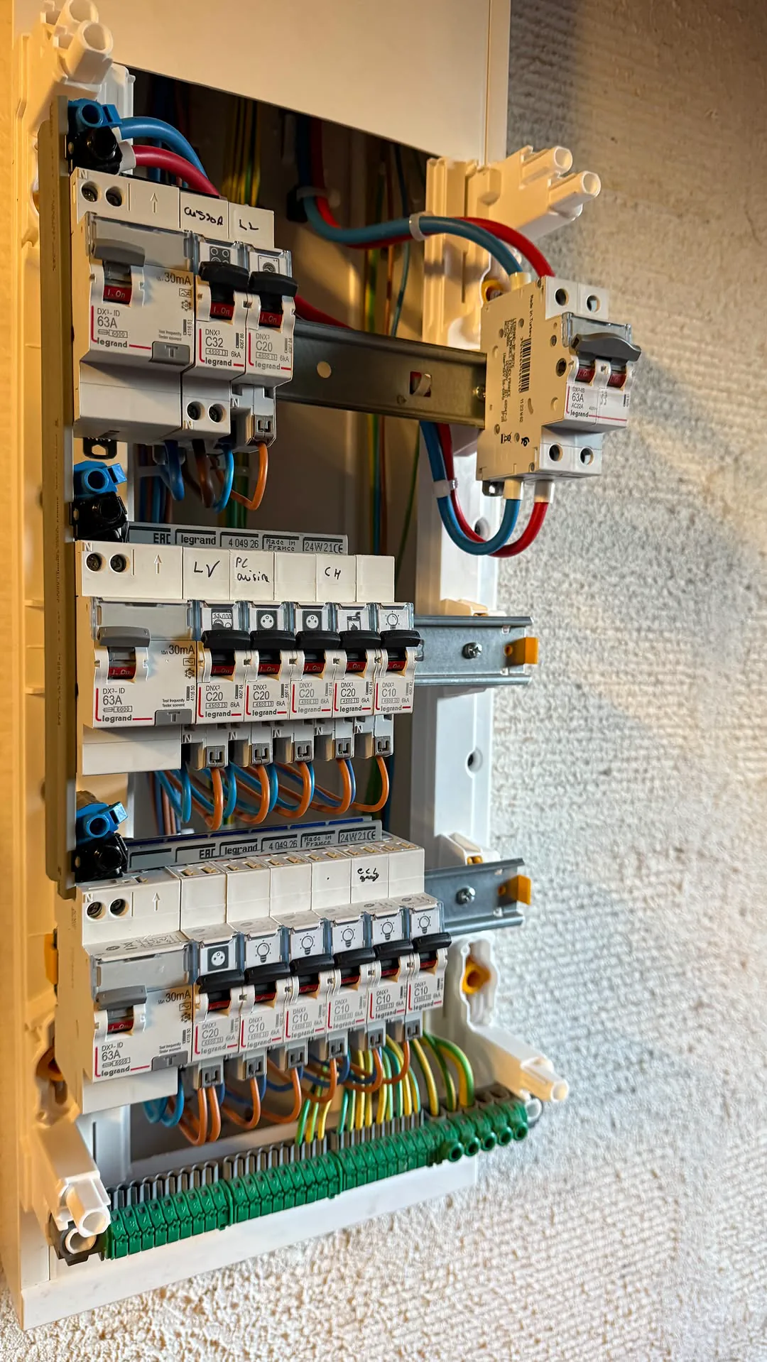 Tableau électrique ouvert avec rangées de protections et câblage repéré